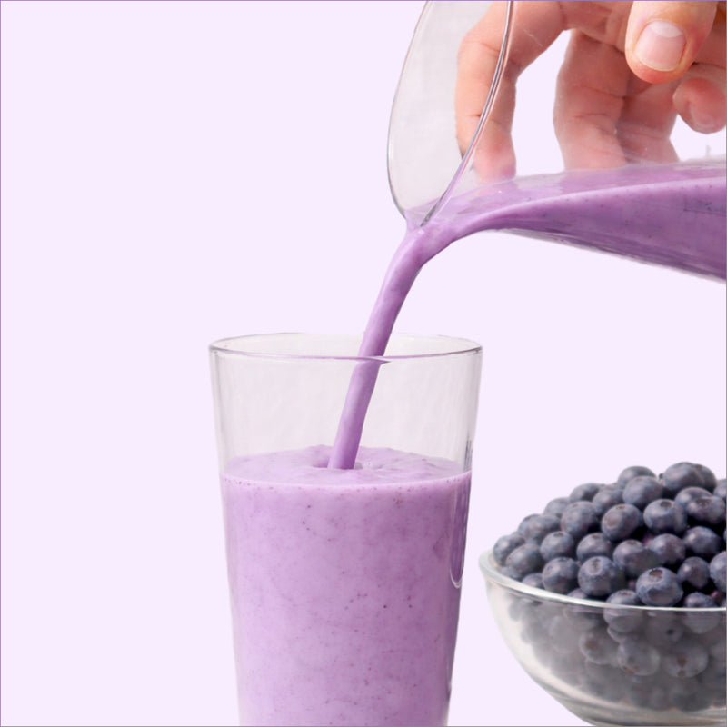 40793201049649  Purple smoothie being poured into a glass with blueberries on a white background