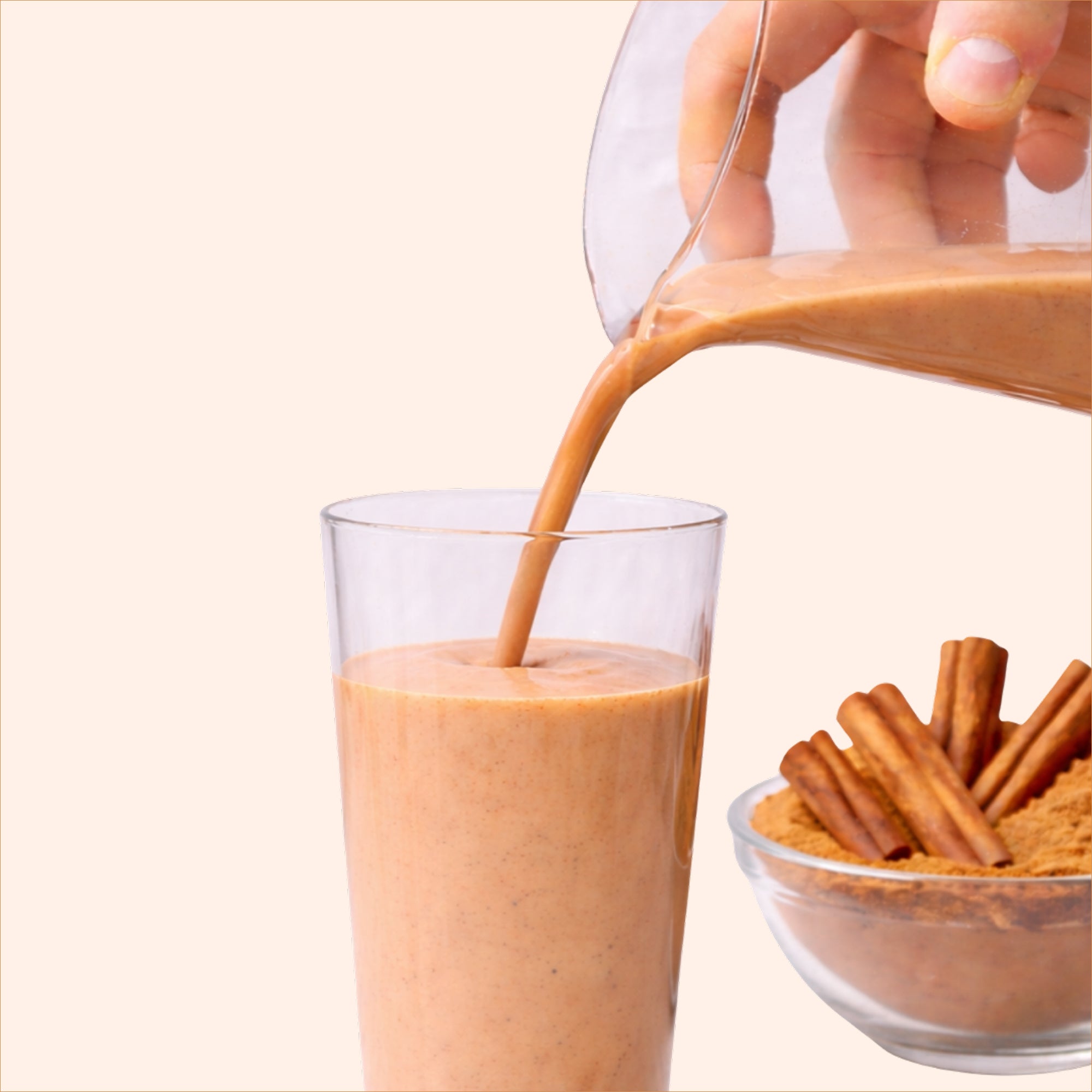40738732539953  Cinnamon roll shake being poured into a glass with cinnamon sticks on a white background