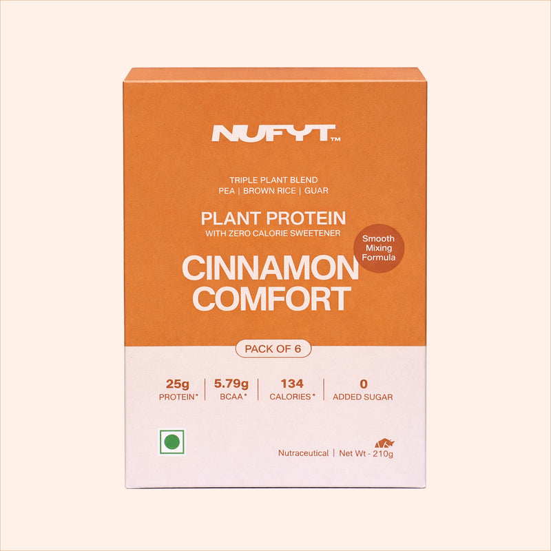 40738732572721 NUFYT Plant Protein Cinnamon Comfort package with a glass of protein shake and cinnamon sticks on a beige background